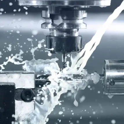 Close-Up Of A Cnc Machine Turning A Metal Prototype. Coolant Fluid Is Being Sprayed To Reduce Heat And Friction. The Image Shows The Precise Engineering Process, With Metal Shavings And Water Splashing Around The Cutting Area.