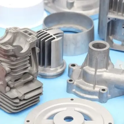 A Collection Of Various Engine And Machinery Parts Made Of Metal, Created Through Rapid Die Casting, Including A Finned Cylinder Component, A Cylindrical Part With Radial Fins, And Other Uniquely Shaped Mechanical Components, Arranged On A Light Blue Surface.