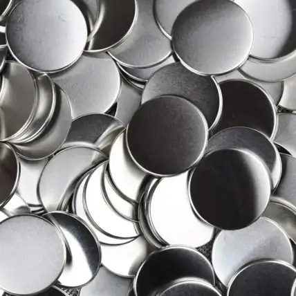 A Close-Up View Of A Pile Of Round, Silver-Colored Metal Discs Cut With Prototype Waterjet Cutting. The Discs Are Overlapping Randomly, Creating A Textured Surface With Highlights And Shadows.