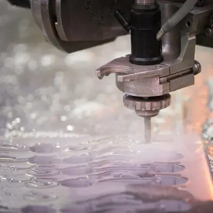 A Close-Up Of A Prototype Waterjet Cutting Machine Precisely Slicing Through A Sheet Of Metal. Water And Debris Are Visible Around The Cutting Area, Demonstrating The Intense Cutting Process. The Background Is Blurred, Drawing Attention To The Machine'S Nozzle And The Cutting Action.