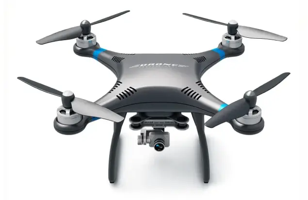 A Sleek, Silver Quadcopter Drone With Four Propellers And Blue Accents Is Shown. It Features A Camera Mounted On Its Underside For Aerial Photography And Videography. The Drone Is Positioned Against A White Background.