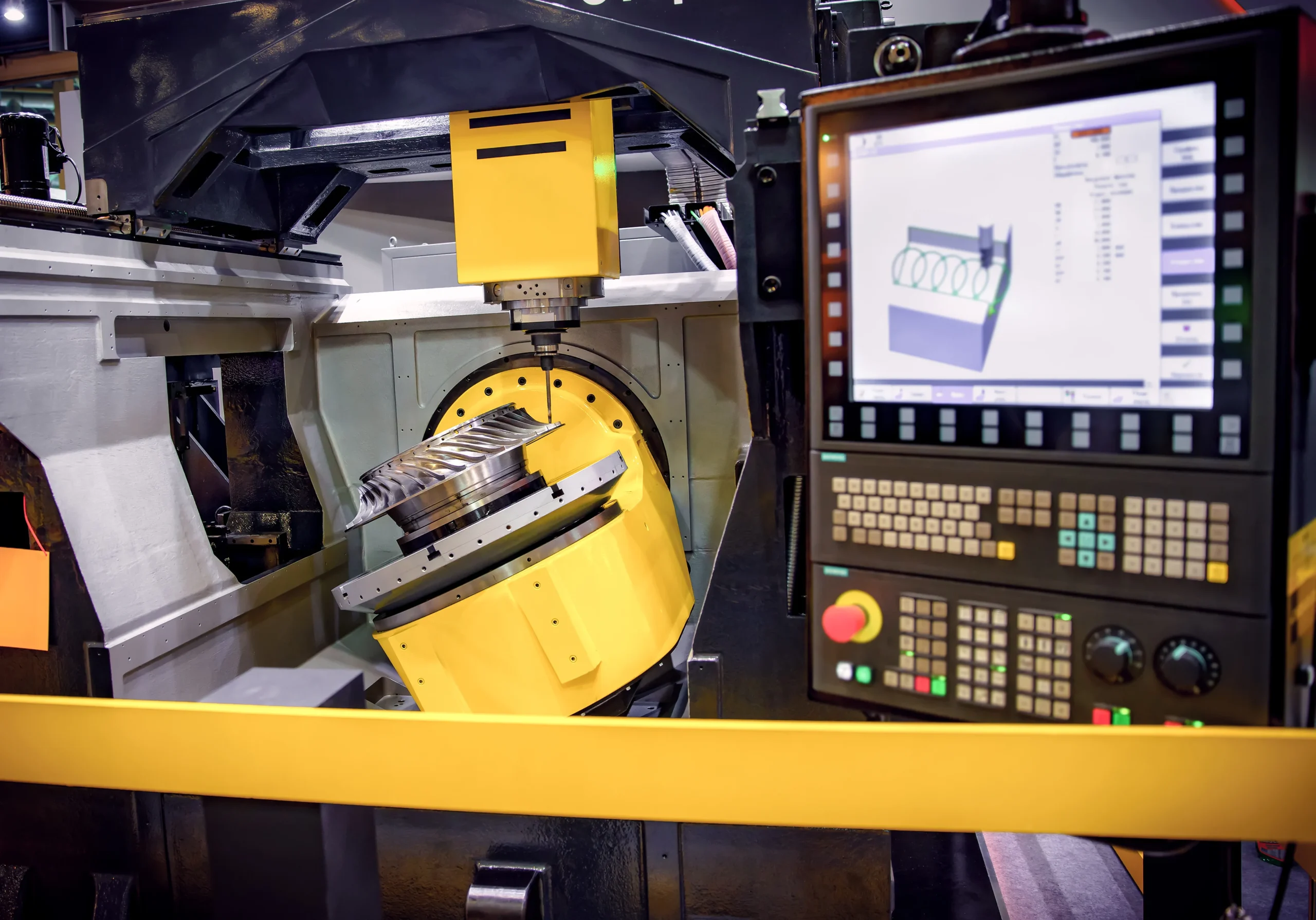 A CNC machine in operation, showcasing its control panel with numerous buttons and a digital display. A metallic workpiece is being machined, indicating a manufacturing process in progress. The setting is well-lit and industrial.