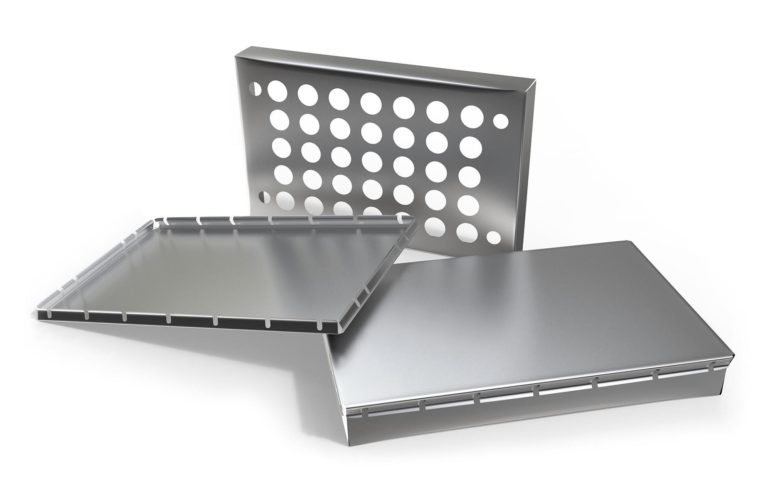 Three metal baking trays are shown: one with a flat surface, one with circular perforations, and a third with a raised edge. They are arranged at various angles on a white background.