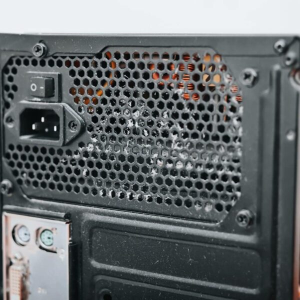 Close-Up Of The Back Panel Of A Desktop Computer Case, Featuring Custom Computer Enclosures With A Power Supply Unit, On/Off Switch, Power Socket, Ventilation Holes, And Partially Visible Motherboard Ports.