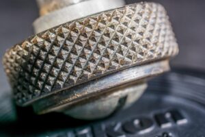 Close-Up Of A Textured, Metallic Knob With Evident Rust And Wear, Featuring Detailed Diamond Knurling.